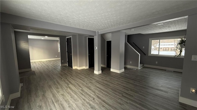 empty room with dark wood-type flooring and a textured ceiling