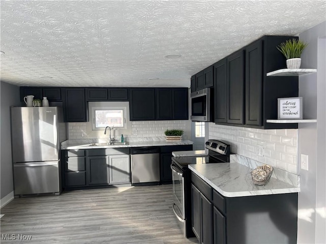 kitchen with stainless steel appliances, light hardwood / wood-style floors, and sink