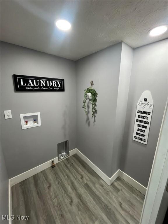 laundry room featuring washer hookup, hardwood / wood-style floors, and a textured ceiling