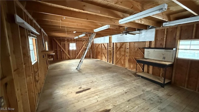 basement featuring hardwood / wood-style floors and wooden walls