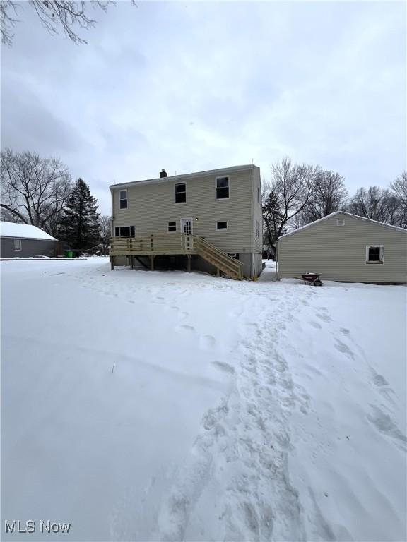 view of snow covered rear of property