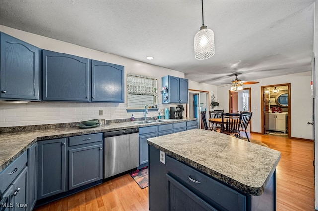 kitchen with a kitchen island, decorative light fixtures, dishwasher, sink, and blue cabinetry