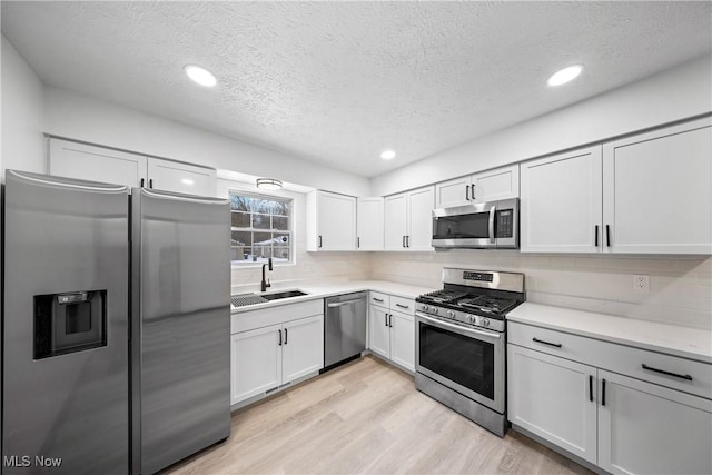 kitchen featuring white cabinetry, appliances with stainless steel finishes, sink, and decorative backsplash