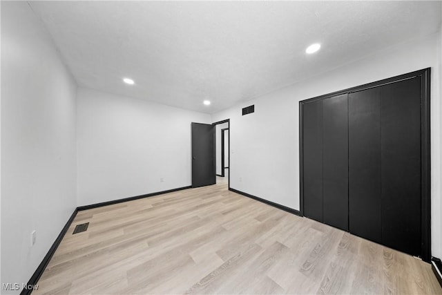 unfurnished bedroom with light hardwood / wood-style floors and a closet