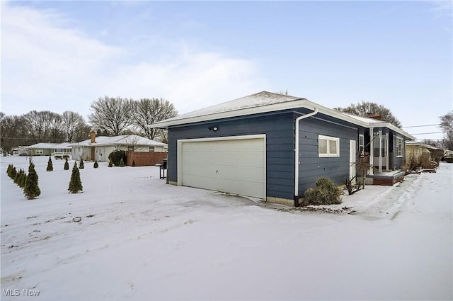 view of snowy exterior with a garage