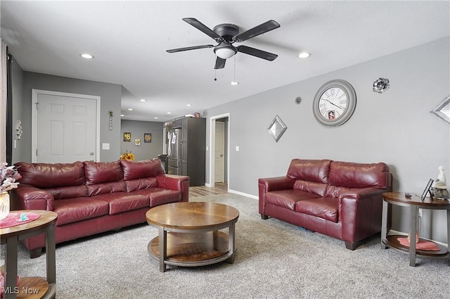 carpeted living room with ceiling fan