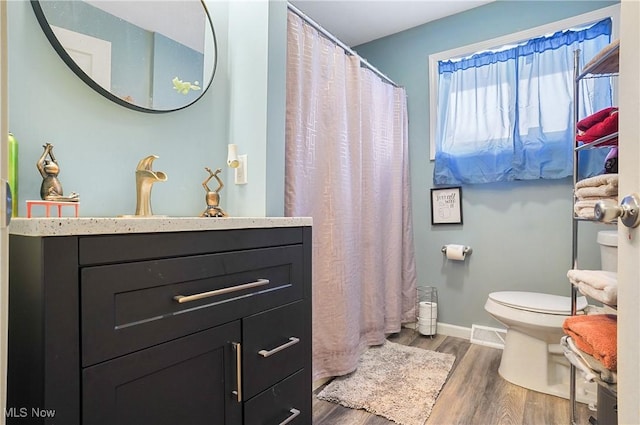 bathroom featuring hardwood / wood-style flooring, vanity, and toilet