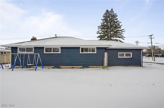 view of snow covered back of property