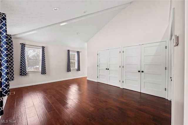 unfurnished bedroom featuring dark hardwood / wood-style flooring and vaulted ceiling with beams