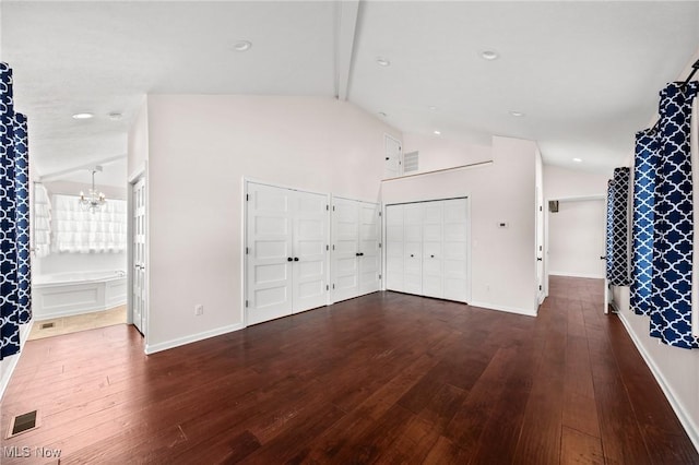 interior space featuring dark hardwood / wood-style flooring, high vaulted ceiling, and an inviting chandelier