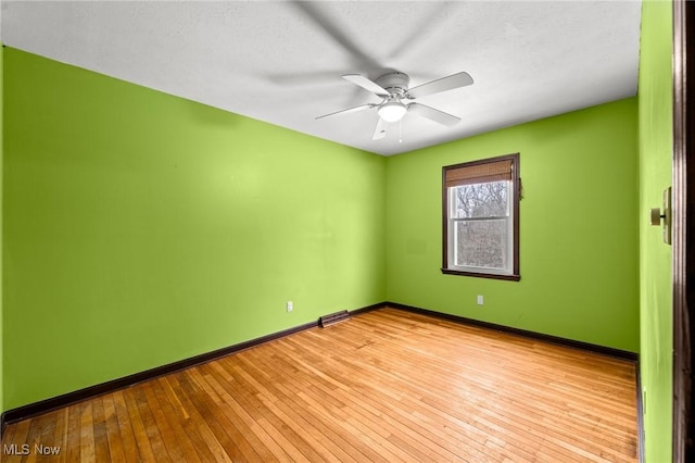 empty room featuring ceiling fan and light hardwood / wood-style floors