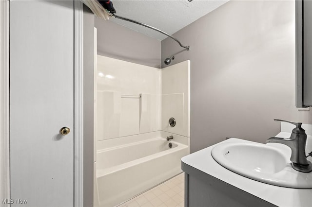 bathroom featuring washtub / shower combination, vanity, and a textured ceiling