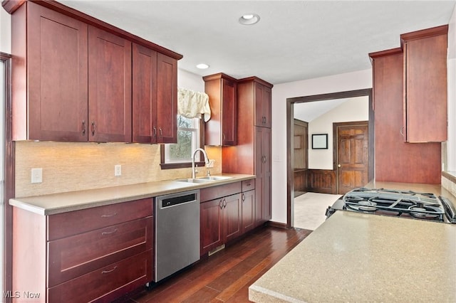 kitchen featuring lofted ceiling, sink, dark hardwood / wood-style flooring, dishwasher, and stove