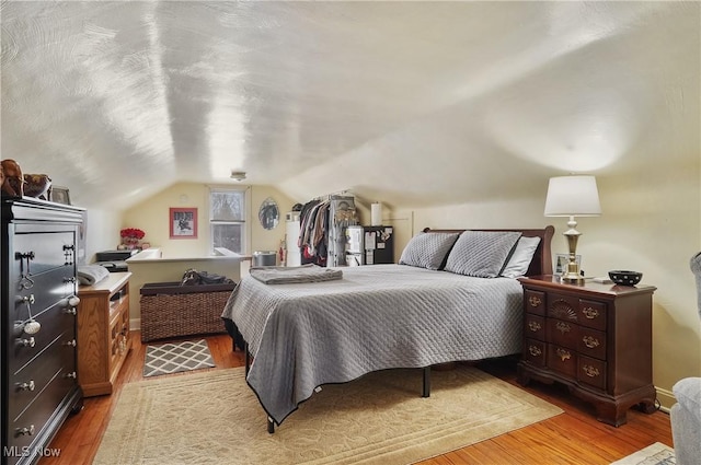 bedroom with lofted ceiling and light wood-type flooring