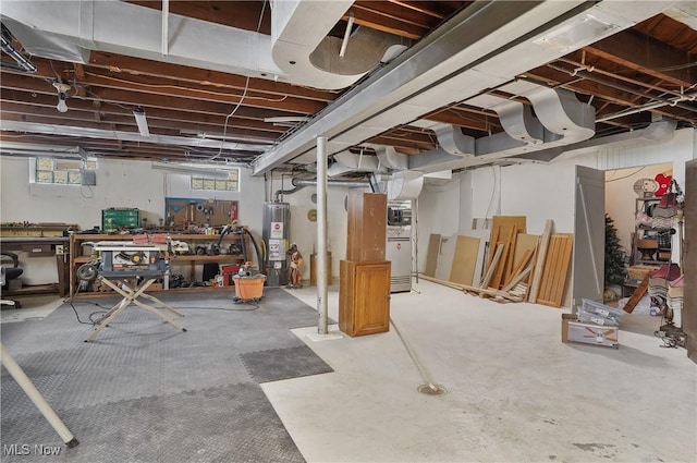 basement with water heater and a workshop area