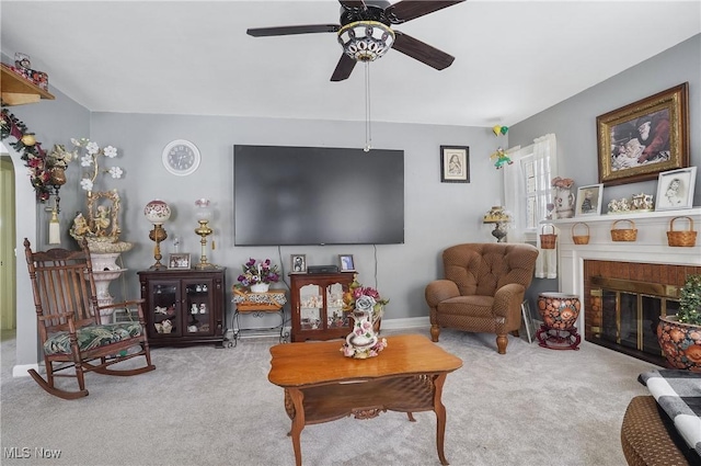 carpeted living room featuring ceiling fan and a brick fireplace