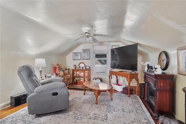 living room with vaulted ceiling, ceiling fan, and light hardwood / wood-style flooring