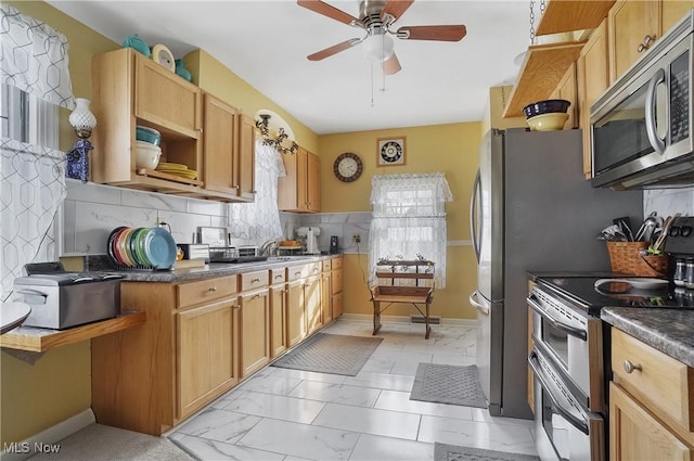 kitchen featuring stainless steel appliances, tasteful backsplash, sink, and ceiling fan