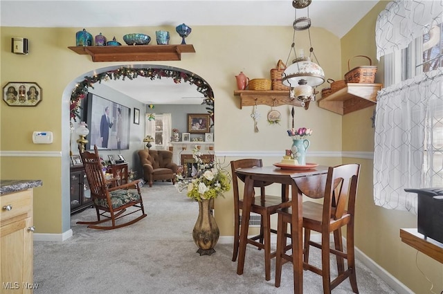 carpeted dining space with a fireplace