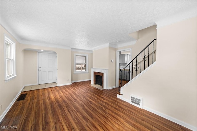 unfurnished living room with hardwood / wood-style flooring, a textured ceiling, and a fireplace
