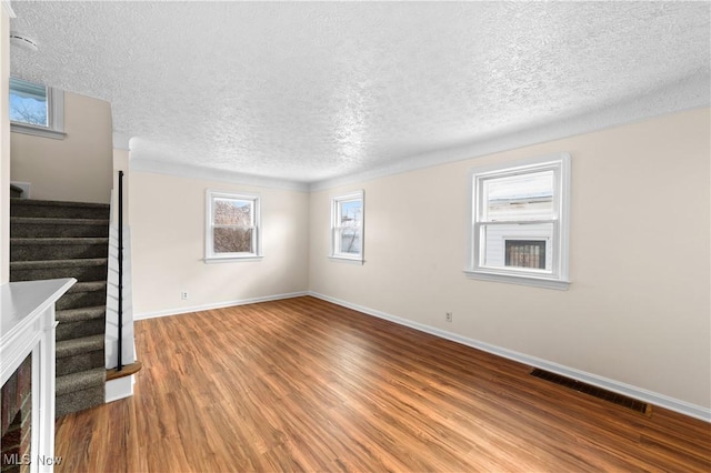 unfurnished living room with hardwood / wood-style floors and a textured ceiling
