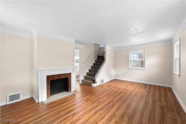 unfurnished living room with hardwood / wood-style flooring, plenty of natural light, a textured ceiling, and a fireplace