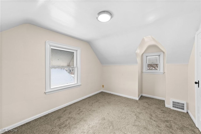 bonus room featuring vaulted ceiling and light carpet