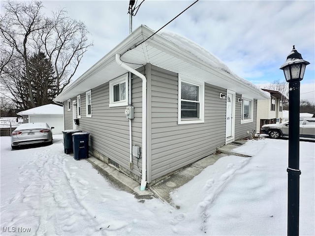 snow covered property with an outbuilding and a garage