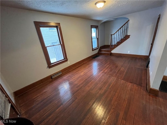 unfurnished room featuring wood-type flooring and a textured ceiling