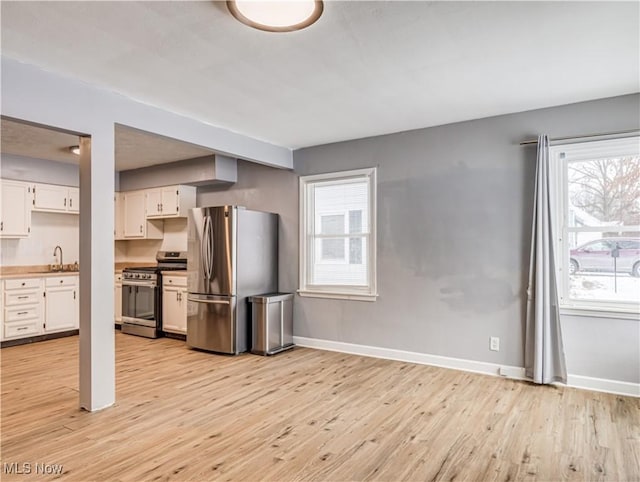 kitchen featuring white cabinetry, appliances with stainless steel finishes, sink, and light hardwood / wood-style flooring