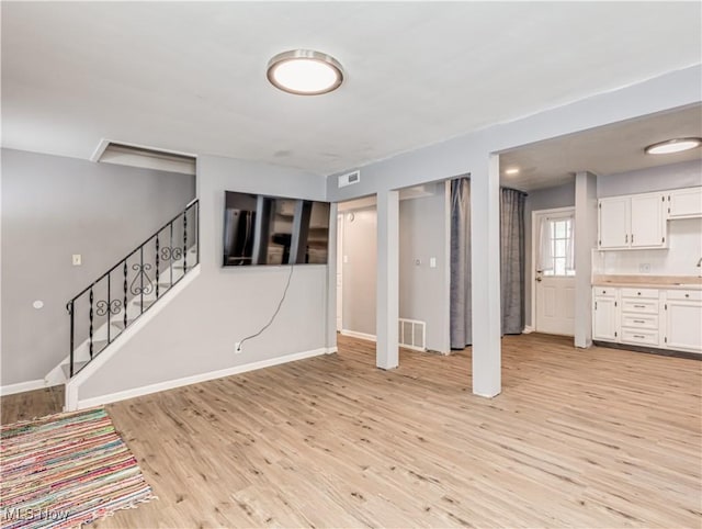 basement featuring sink and light wood-type flooring