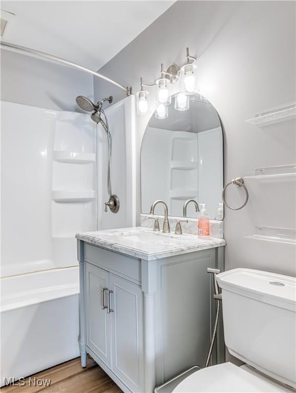 full bathroom with shower / bathtub combination, wood-type flooring, toilet, and vanity