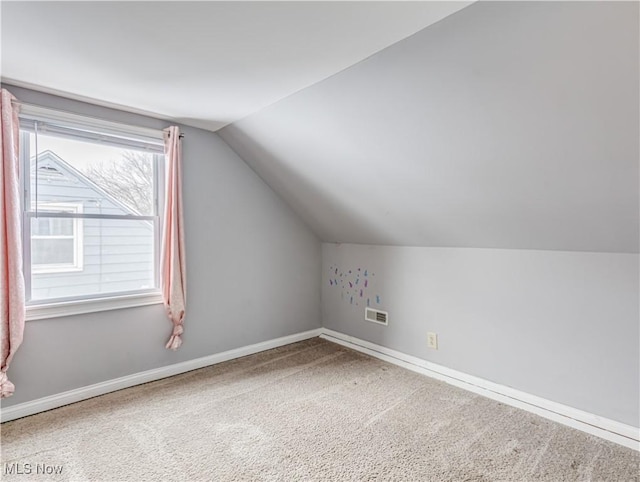 bonus room featuring vaulted ceiling and carpet