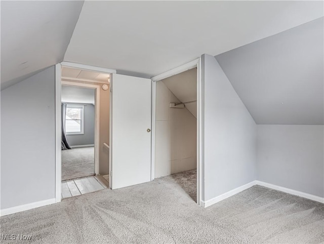 additional living space with light carpet and vaulted ceiling