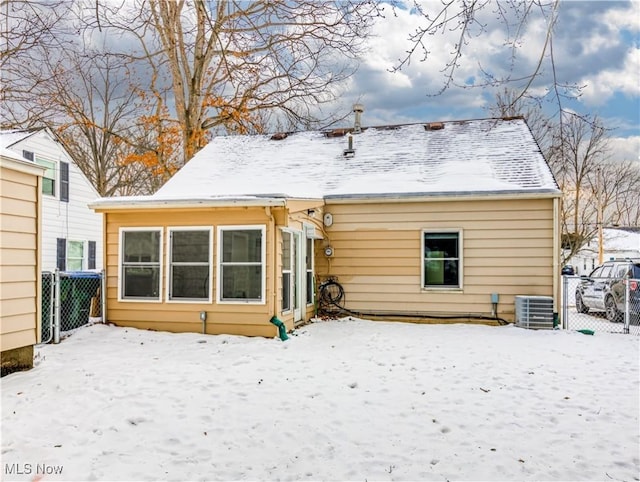 snow covered house with central air condition unit