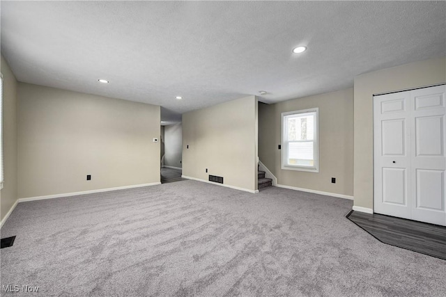 carpeted empty room featuring a textured ceiling