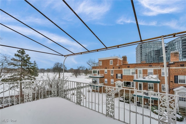 view of snow covered back of property