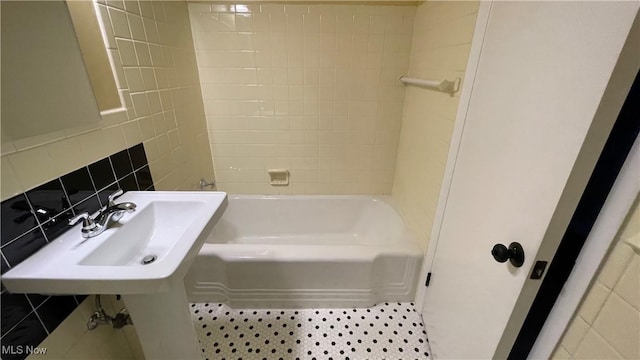 bathroom featuring tile patterned floors, sink, tile walls, and backsplash