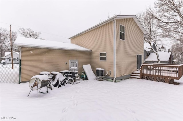 snow covered back of property featuring a wooden deck and cooling unit