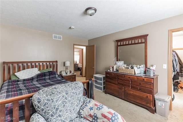 carpeted bedroom featuring a textured ceiling and a closet