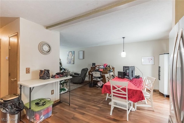 dining area with hardwood / wood-style flooring and beamed ceiling