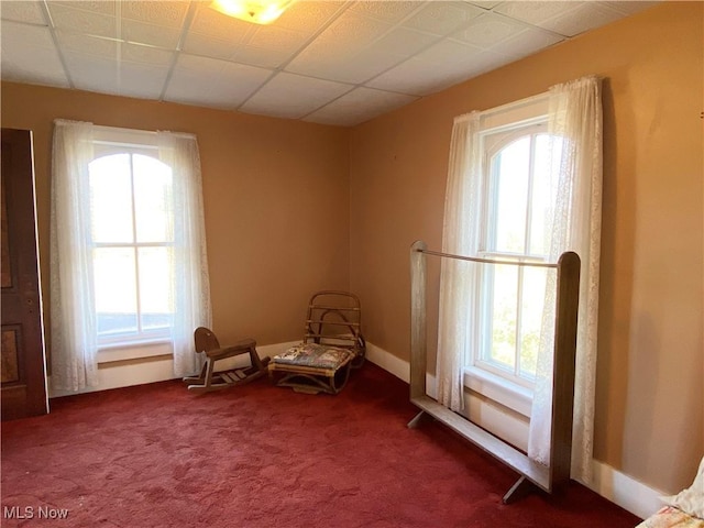 unfurnished room with a wealth of natural light and dark carpet