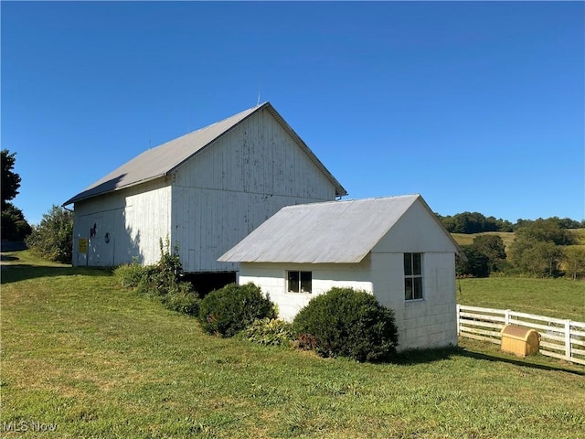 view of side of property featuring an outdoor structure and a lawn