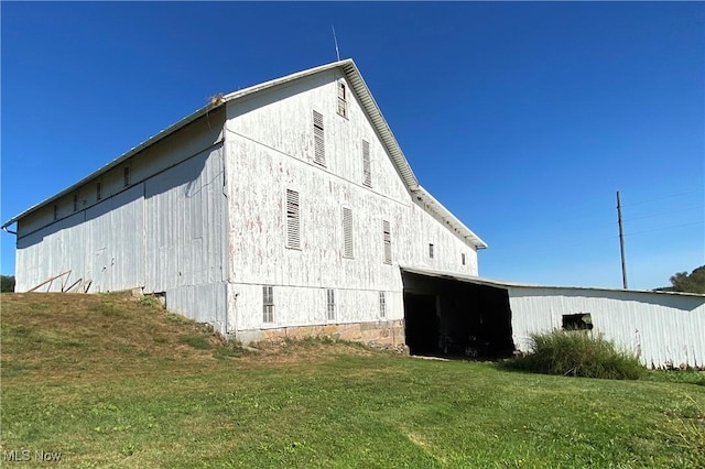 view of side of home with a yard and an outbuilding