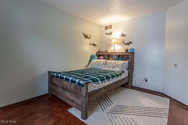 bedroom with dark hardwood / wood-style floors