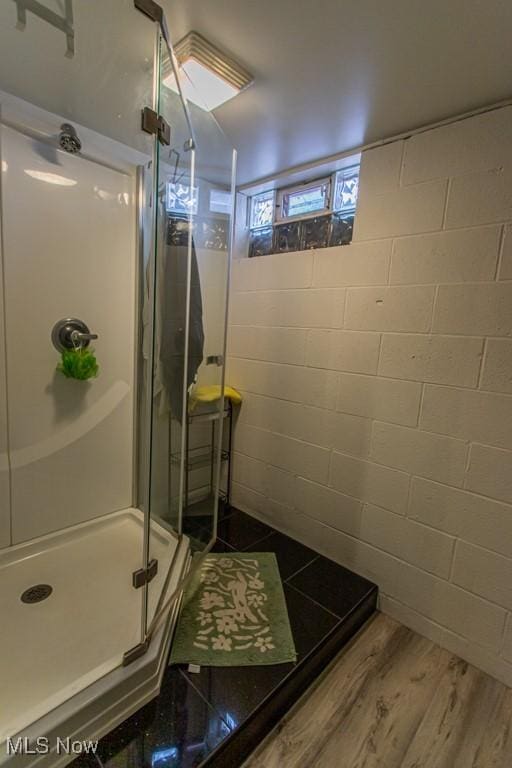 bathroom featuring wood-type flooring and an enclosed shower