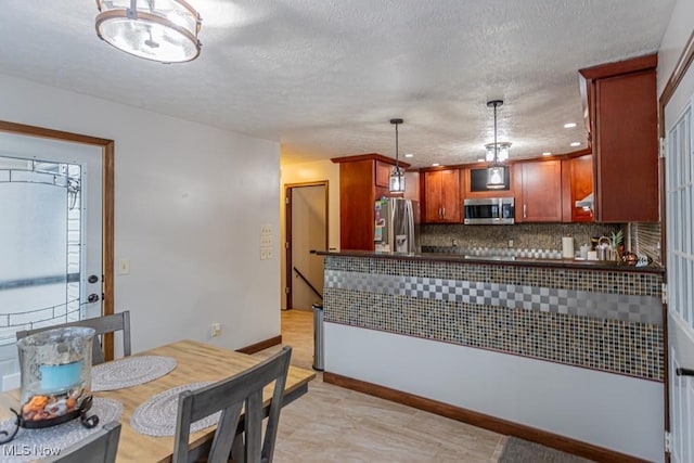 kitchen featuring tasteful backsplash, stainless steel appliances, decorative light fixtures, and light tile patterned floors