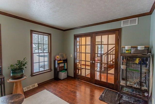 doorway to outside with ornamental molding, a textured ceiling, dark hardwood / wood-style flooring, and french doors