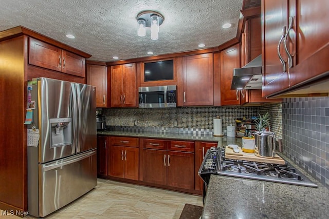 kitchen featuring stainless steel appliances, dark stone counters, decorative backsplash, and exhaust hood