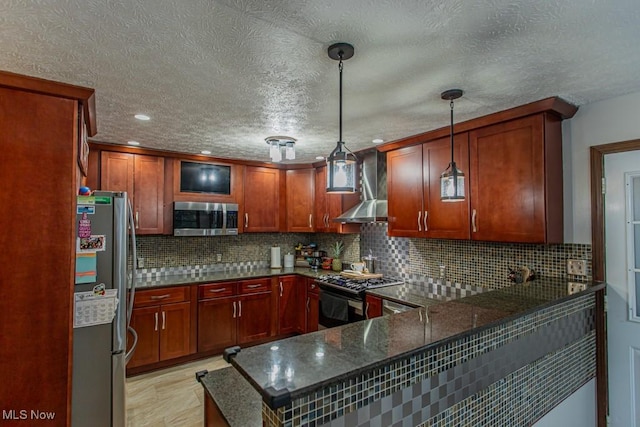 kitchen with stainless steel appliances, hanging light fixtures, wall chimney exhaust hood, and kitchen peninsula